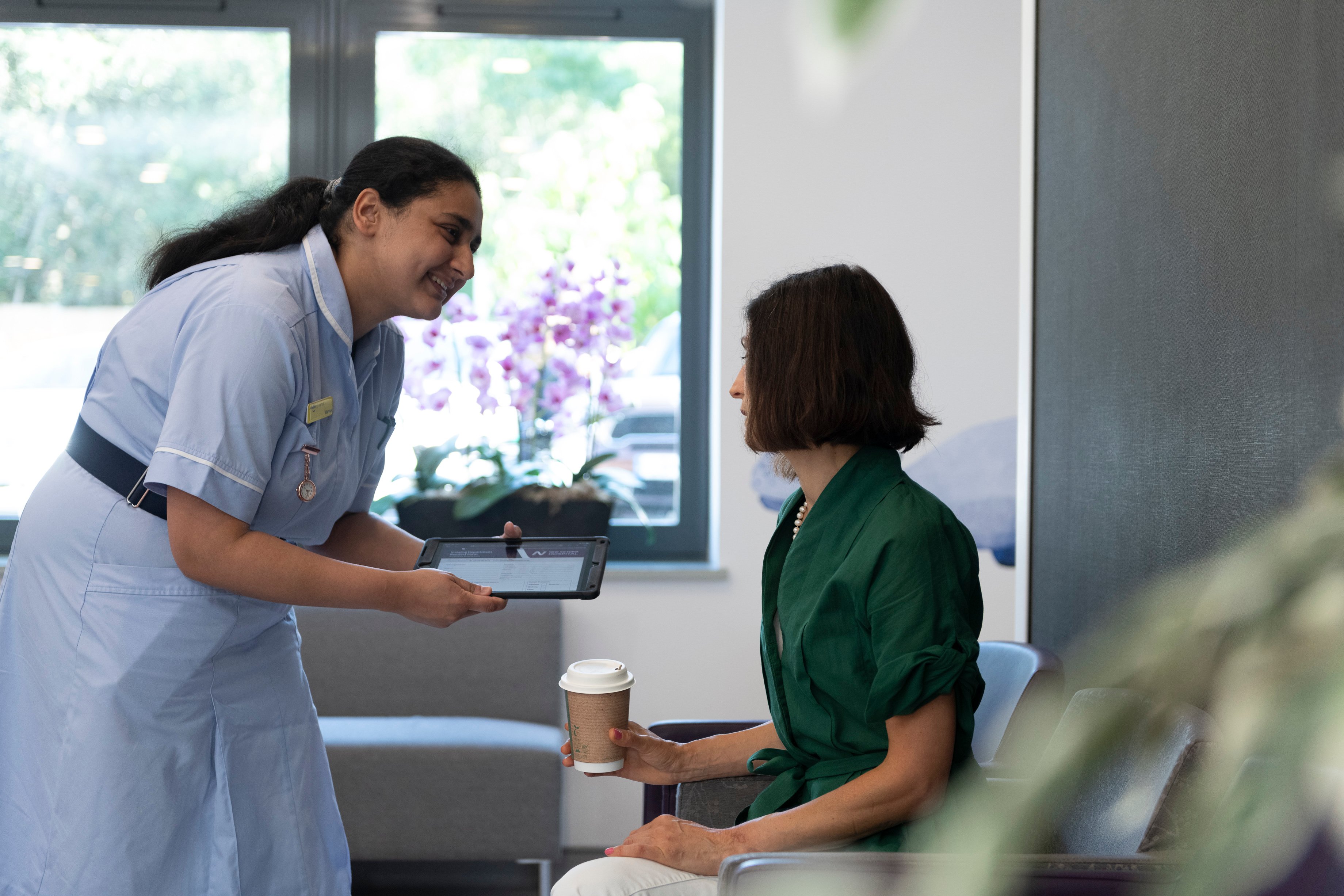 women in a waiting room talking to a patient 