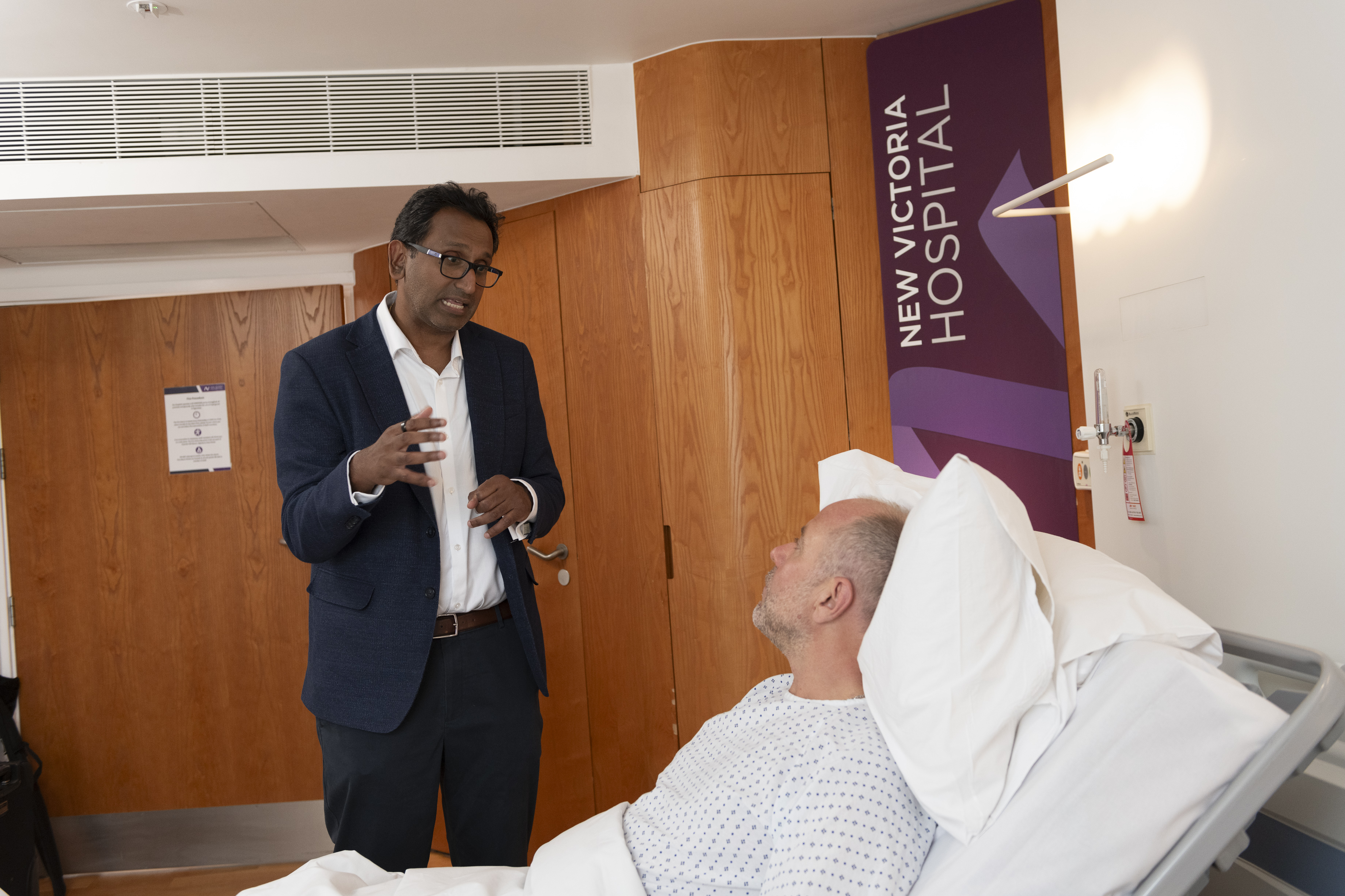 Urology Consultant talking to a patient in a hospital bed