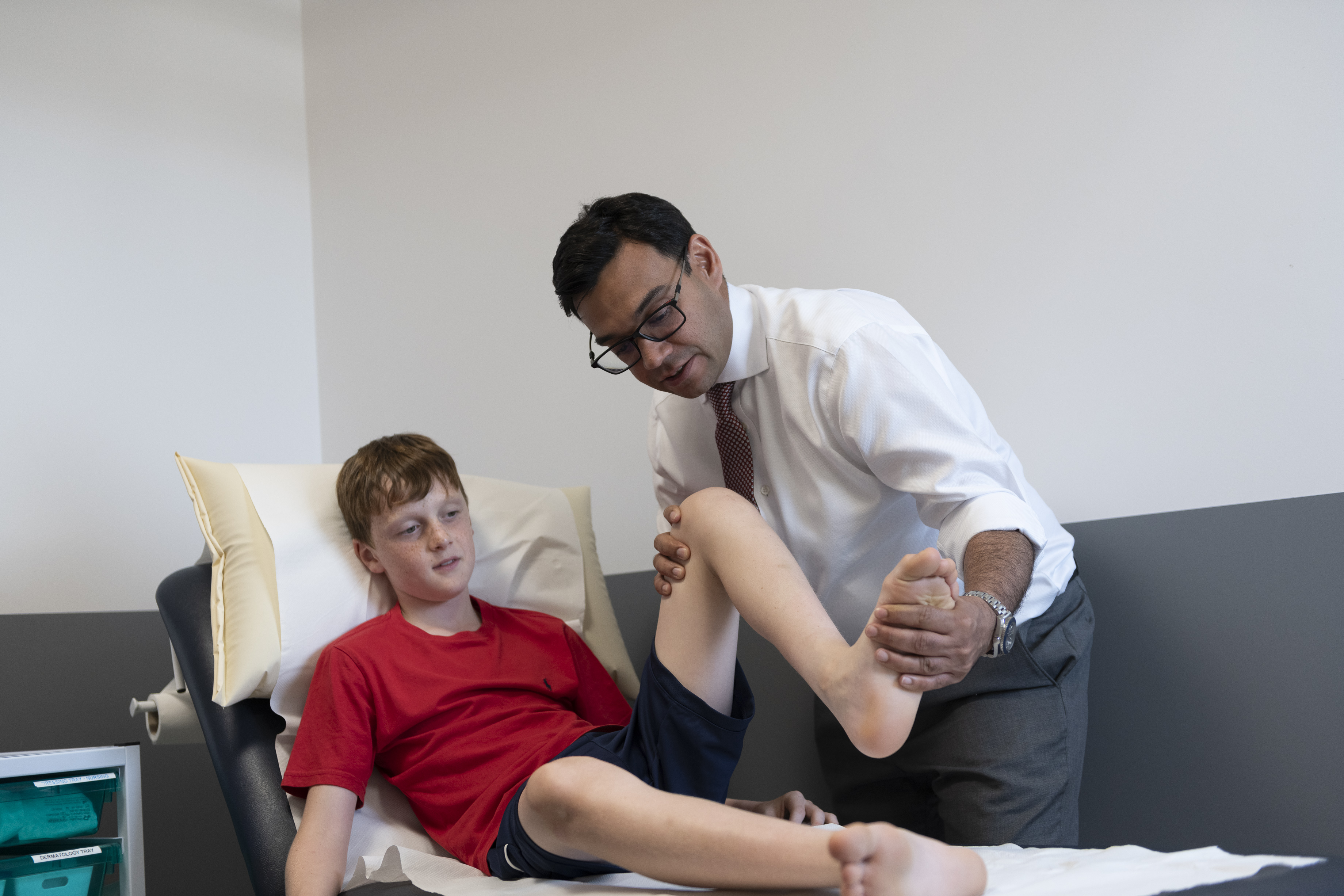 Mr Anshul Sobti with a child patient checking his leg 